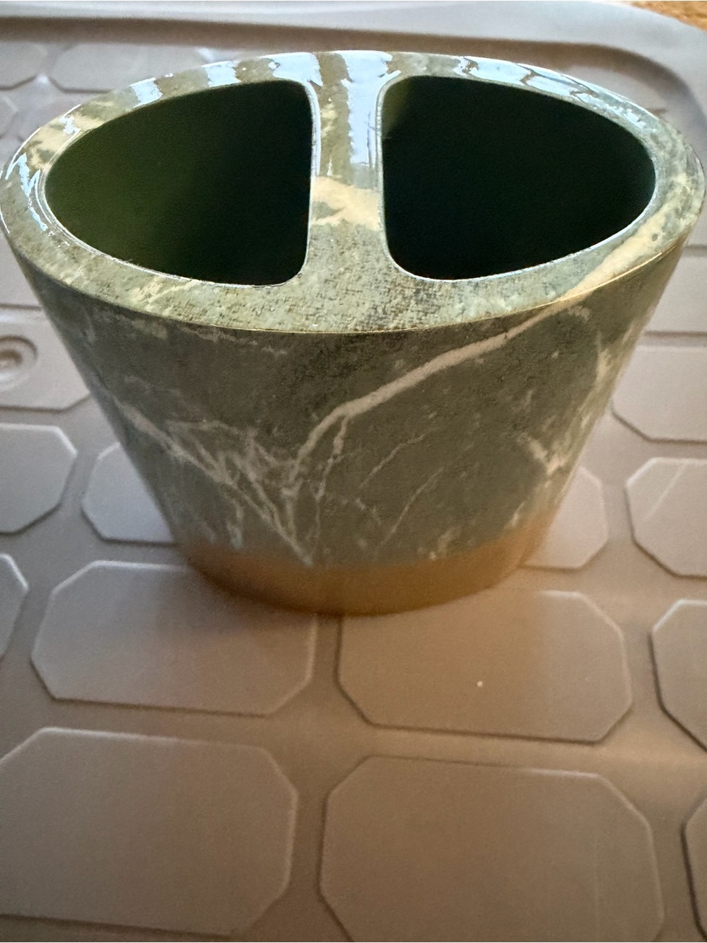 Toothbrush holder green marble pattern with gold colored base.